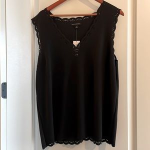 Black, sleeveless top with laser-cut detail at neck and arms